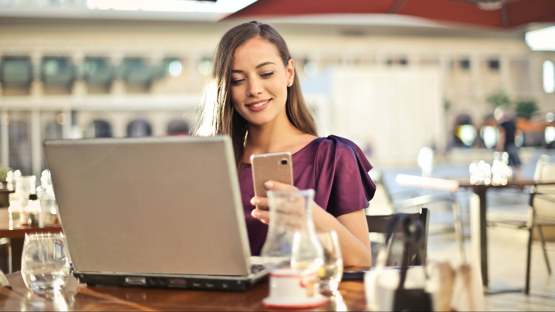 woman wearing purple shirt holding smartphone white sitting on chair